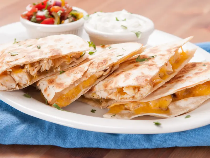 Meksika mutfağından bir quesadilla örneği; peynirle doldurulup katlanmış ve üçgen şeklinde dilimlenmiş tortilla.